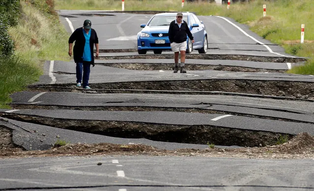 Local residents Chris and Viv Young look at damage caused by an earthquake, along State Highway One near the town of Ward, south of Blenheim on New Zealand's South Island, November 14, 2016. (Photo by Anthony Phelps/Reuters)