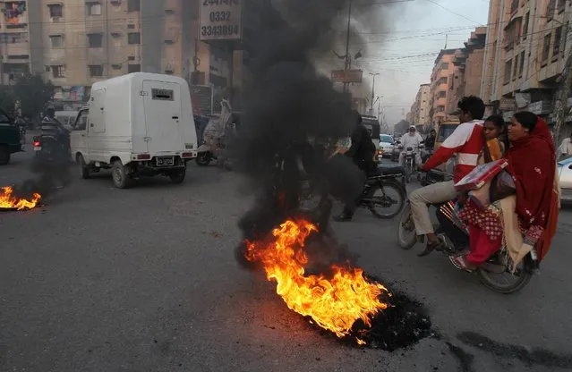 Pakistani protesters burn tires to condemn a blast at a Shiite mosque, Friday, January 30, 2015 in Karachi, Pakistan. The bomb ripped through a mosque in Pakistan belonging to members of the Shiite minority sect of Islam just as worshippers were gathering for Friday prayers, killing dozens of people and wounding many others, officials said. (Photo by Fareed Khan/AP Photo)
