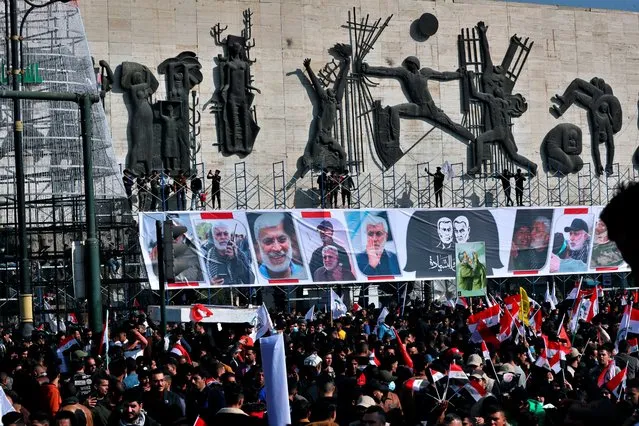 Supporters of the Popular Mobilization Forces hold a posters of Abu Mahdi al-Muhandis, deputy commander of the Popular Mobilization Forces, front, and General Qassem Soleimani, head of Iran's Quds force during a protest, in Tahrir Square, Iraq, Sunday, January 3, 2021. Thousands of Iraqis converged on a landmark central square in Baghdad on Sunday to commemorate the anniversary of the killing of Soleimanil and al-Muhandis in a U.S. drone strike. (Photo by Khalid Moha/AP Photo)