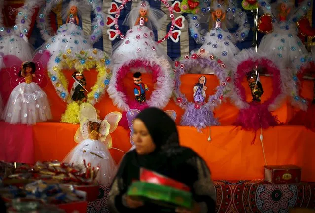 A woman shops for handmade sweets around traditional “Aroset El Moulid” (Bride of Moulid) dolls at a street market ahead of Mawlid al-Nabi, the birthday of Prophet Mohammad, in Old Cairo, Egypt, December 21, 2015. (Photo by Amr Abdallah Dalsh/Reuters)
