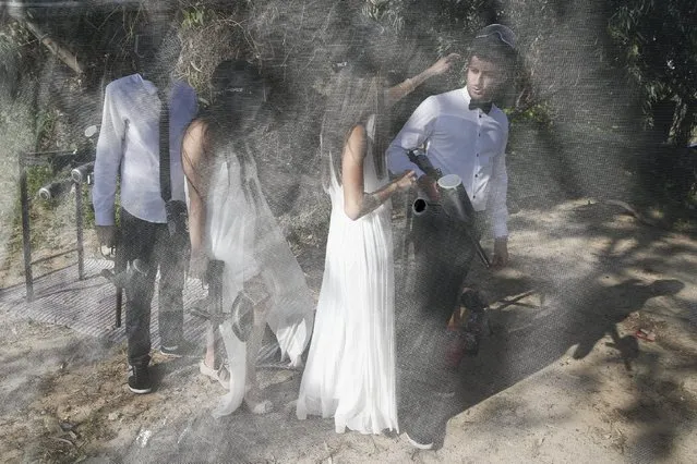 Israeli couples attend a “trash the dress” event at a paint-ball venue in the southern Israeli city of Ashdod, December 25, 2015. (Photo by Amir Cohen/Reuters)