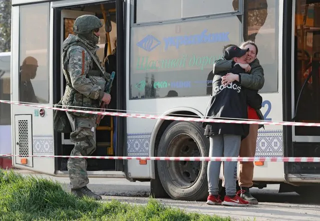Azovstal steel plant employee Valeria, last name withheld, evacuated from Mariupol, hugs her son Matvey, who had earlier left the city with his relatives, as they meet at a temporary accommodation centre during Ukraine-Russia conflict in the village of Bezimenne in the Donetsk Region, Ukraine on May 1, 2022. (Photo by Alexander Ermochenko/Reuters)