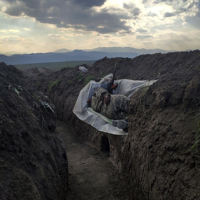 In this image released by World Press Photo, Thursday April 15, 2021, by Vaghinak Ghazaryan, tittle Resting Soldier, which won the third prize in the Contemporary Issues Singles category shows a soldier who lies in a trench, resting on a plastic cover, in the northeastern part of Syunik, Nerkin Khndzoresk, Armenia, on 31 October 2020. (Photo by Vaghinak Ghazaryan, World Press Photo via AP Photo)