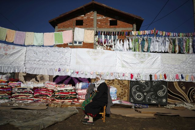 A Bulgarian Muslim woman sits in front of a dowry during the wedding ceremony of Bulgarian Muslims Fikrie Bindzheva and Azim Liumankov in the village of Ribnovo, in the Rhodope Mountains, February 14, 2015. (Photo by Stoyan Nenov/Reuters)