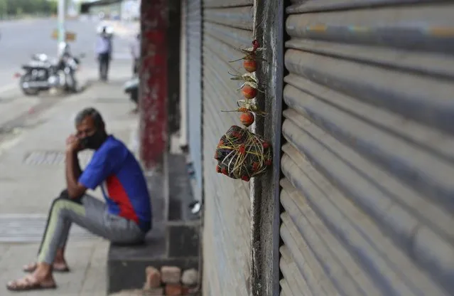 Lemon and chillies, believed to ward away the evil are hung outside a closed shop during restrictions to curb the spread of coronavirus in Jammu, India, Wednesday, May 12, 2021. Misinformation about the coronavirus is surging in India as the death toll from COVID-19 rises. Fueled by anguish, distrust and political polarization, the claims are further compounding India's crisis. (Photo by Channi Anand/AP Photo)