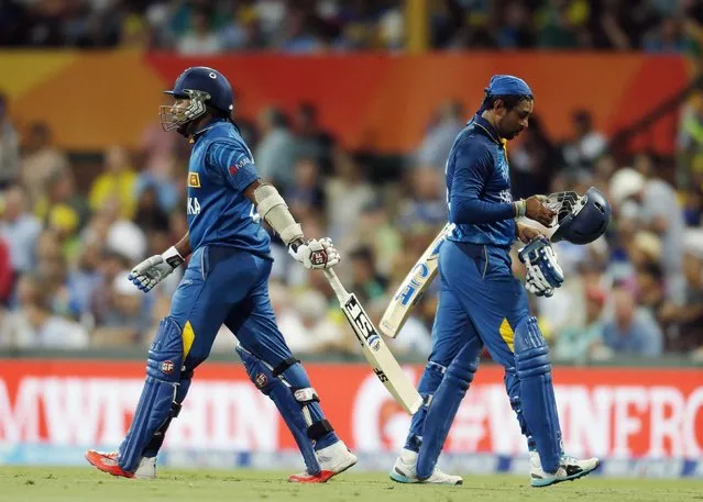Sri Lanka's Tillakaratne Dilshan (R) passes team mate Mahela Jayawardene as he walks from the field after being dismissed by Australia's James Faulkner during their Cricket World Cup match in Sydney, March 8, 2015.    REUTERS/Jason Reed (AUSTRALIA - Tags: SPORT CRICKET)