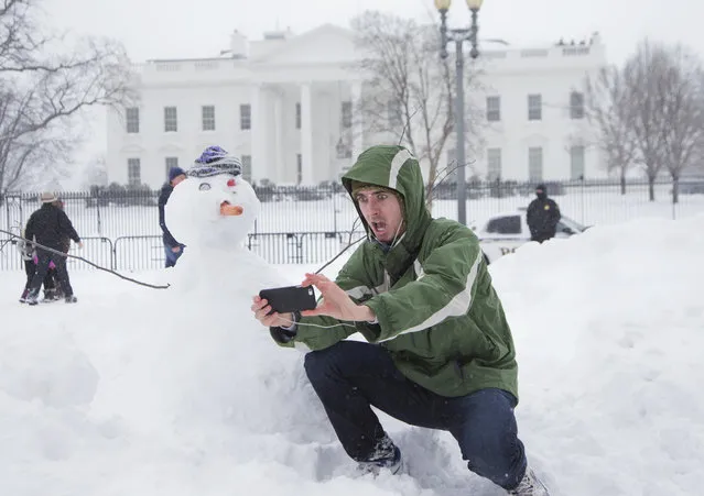 Harrison Feind of Boulder, Colo., takes a selfie with a snowman in front of the White House in Washington, Saturday, January 23, 2016. A blizzard with hurricane-force winds brought much of the East Coast to a standstill Saturday, dumping as much as 3 feet of snow, stranding tens of thousands of travelers and shutting down the nation's capital and its largest city. (Photo by Manuel Balce Ceneta/AP Photo)
