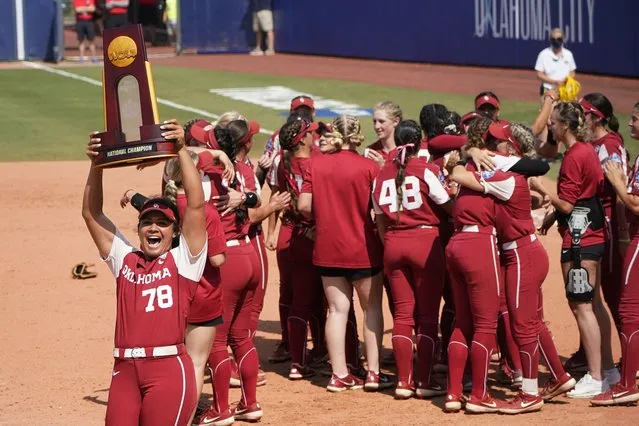 Oklahoma's Jocelyn Alo (78) carries the championship trophy toward the Oklahoma fans as the team celebrates after defeating Florida State in the final game of the NCAA Women's College World Series softball championship series Thursday, June 10, 2021, in Oklahoma City. (Photo by Sue Ogrocki/AP Photo)