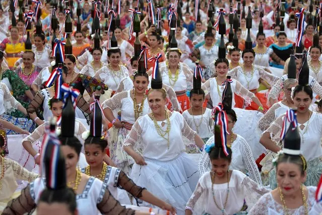 “Bottle dancers”, a Paraguayan traditional folk dance in which performers dance with glass bottles balanced on their heads, attempt to set a record at the Official World Record Association (OWR) on the first edition of the National Day of the Bottle Women, at the Bicentennial Park in Asuncion on September 17, 2023. Paraguay obtained an Official World Record when 580 dancers balanced 2200 bottles on their heads at the same time. (Photo by Norberto Duarte/AFP Photo)