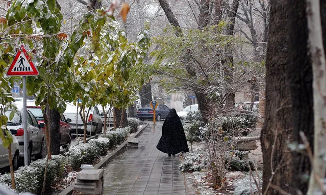 An Iranian woman walks during a snowfall in Tehran, Iran, 06 December 2015. Tehran was hit by the first snowfall, as the temperature fall to as low as two degrees Celsius. (Photo by Abedin Taherkenareh/EPA)