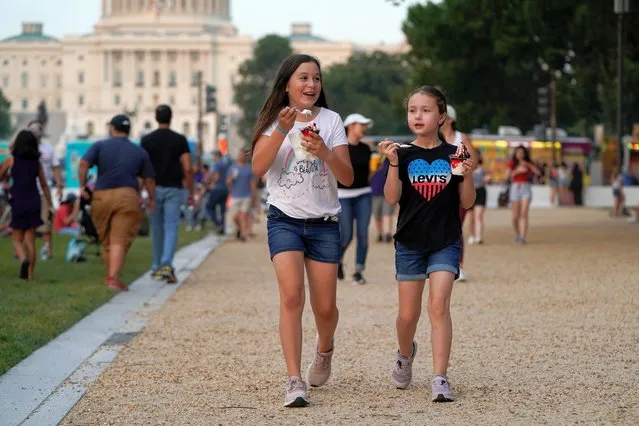 Children walk eating ice creams as people gather for the annual Independence Day fireworks celebration at the National Mall in Washington, U.S., July 4, 2021. (Photo by Joshua Roberts/Reuters)