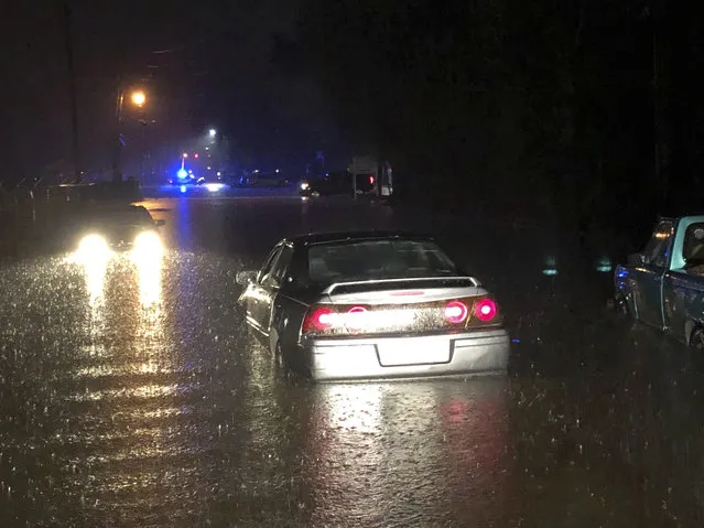 In this photo provided by the Hattiesburg Police Department, released drivers attempt to drive through flash flood waters on Providence Street in Hattiesburg, Miss., Thursday, December 27, 2018. A storm system dumped up to 12 inches of rain in Louisiana and Mississippi, Thursday afternoon through early Friday morning. (Photo by Ryan Moore/Hattiesburg Police Department via AP Photo)