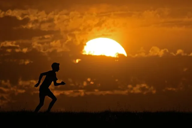 A runner is silhouetted at sunset Tuesday, October 10, 2023, in Shawnee, Kan. (Photo by Charlie Riedel/AP Photo)