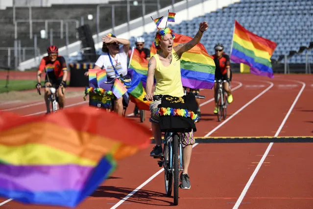 Attendees of The WorldPride 2021 cheer during the opening parade at Malmo Stadium on August 12, 2021. This year's WorldPride will be held in Malmo and Copenhagen between the August 12-22 including two Pride parades, parties, music performances, a Youth park, art and culture and a gigantic WorldPride House. (Photo by Johan Nilsson/TT News Agency/AFP Photo)