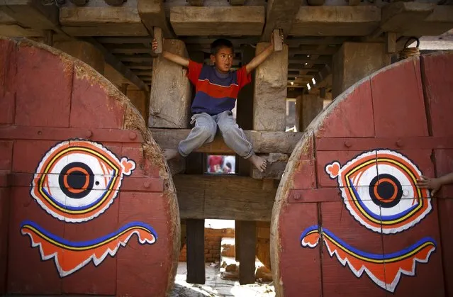 A boy plays on the chariot of God Bhairab before pulling the chariot during the Bisket festival at Bhaktapur April 10, 2015. (Photo by Navesh Chitrakar/Reuters)