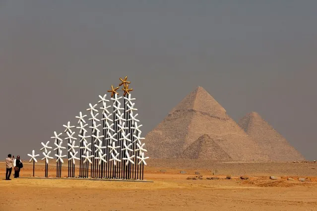 A woman takes a photo beside the project “As Above, So Below (Dome of Starry Sky)” by Mohamed Banawy, during The Edition III at Pyramids of Giza, in front of the Great Pyramids of Giza, on the outskirt of Cairo, Egypt on October 26, 2023. (Photo by Mohamed Abd El Ghany/Reuters)