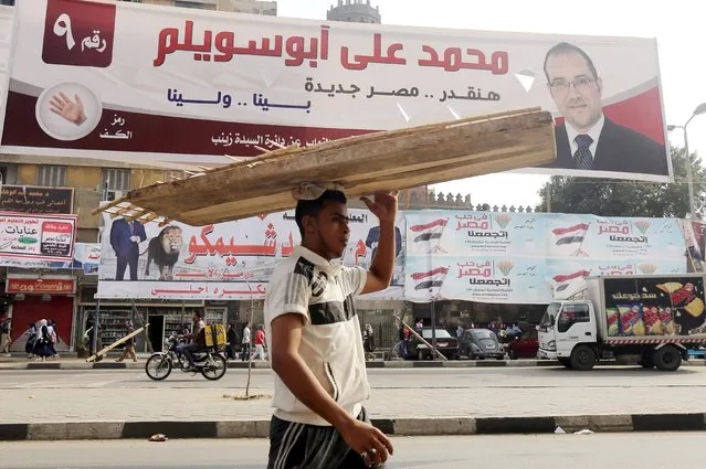 A street vendor walks under election campaign banners in downtown Cairo, ahead of the second round of parliamentary election, November 19, 2015. (Photo by Mohamed Abd El Ghany/Reuters)
