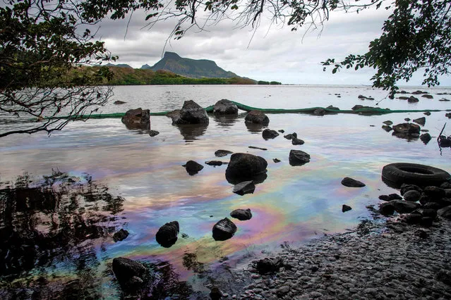 A picture taken on August 15, 2020 shows iridescence on the water at the beach in Petit Bel Air, due to the oil leaked from vessel MV Wakashio, belonging to a Japanese company but Panamanian-flagged, that ran aground near Blue Bay Marine Park off the coast of south-east Mauritius. A fresh streak of oil spilled on August 14, 2020, from a ship stranded on a reef in pristine waters off Mauritius, threatening further ecological devastation as demands mount for answers as to why the vessel had come so close to shore. (Photo by Fabien Dubessay/AFP Photo)