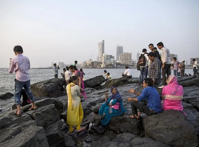 People sit on the rocks along the Arabian Sea next to Haji Ali Shrine in Mumbai April 9, 2015. (Photo by Danish Siddiqui/Reuters)