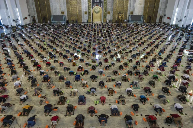 Muslims take part in congregational Friday prayers with social distancing measures in place due to the Covid-19 pandemic at a mosque in Surabaya on August 13, 2021. (Photo by Juni Kriswanto/AFP Photo)