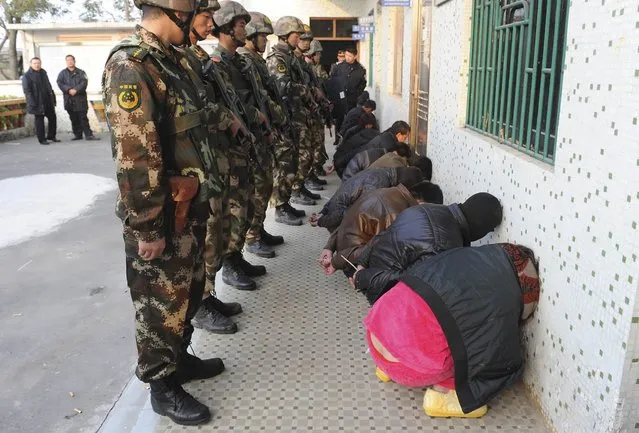 Paramilitary policemen guard suspects during a raid where three tonnes of crystal meth were seized at Boshe village, Lufeng, Guangdong province, December 29, 2013. (Photo by Reuters/Stringer)