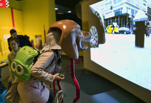 In this Tuesday, March 12, 2019 photo, a visitor takes part in an immersive experience showing visitors how dogs see from inside the head of a dog at the California Science Center in Los Angeles. A new exhibit at a Los Angeles museum examines the relationship between dogs and humans and explores why the two species seem to think so much alike and get along so well. “Dogs! A Science Tail” opens Saturday, March 16, 2019, at the California Science Center. (Photo by Richard Vogel/AP Photo)