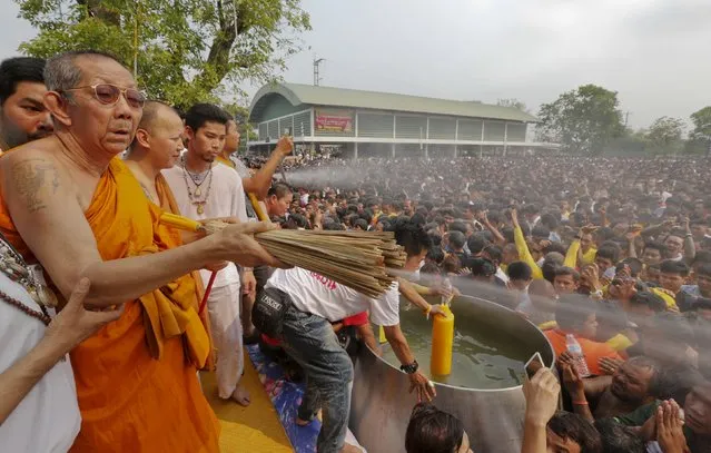 A Buddhist monk sprays devotees with holy water during the annual Magic Tattoo Festival at Wat Bang Phra in Nakhon Pathom province, on the outskirts of Bangkok, Thailand, March 19, 2016. (Photo by Chaiwat Subprasom/Reuters)