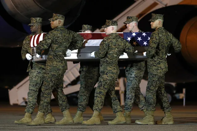 A U.S. Marine Corps carry team moves a transfer case containing the remains of Staff Sgt. Christopher Slutman, Thursday, April 11, 2019, at Dover Air Force Base, Del. According to the Department of Defense, Slutman, of Newark, Del., was among three American service members killed by a roadside bomb on Monday, April 8, near Bagram Airfield in Afghanistan. (Photo by Patrick Semansky/AP Photo)