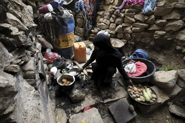 An internally displaced woman washes dishes as she sits in a cave in the district of Khamir of Yemen's northwestern province of Amran May 9, 2015. (Photo by Mohamed al-Sayaghi/Reuters)