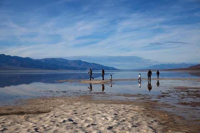 People walk through the still present Lake Manly at Badwater Basin in Death Valley, California, USA, 26 January 2024. Lake Manly was an ancient lake that was once filled with water up to 700 feet deep during the Ice Ages, but had since dried up. Months after an inundation of rain the lake recently reformed. The lake is located in Death Valley, which is considered the driest place in North America. (Photo by Allison Dinner/EPA/EFE)