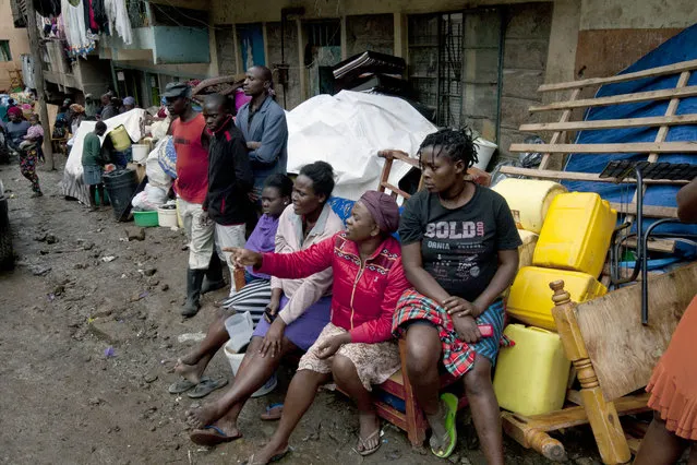 Survivors sit outside after saving their household items, at the site of a building collapse in Nairobi, Kenya, Saturday, April 30, 2016. (Photo by Sayyid Abdul Azim/AP Photo)