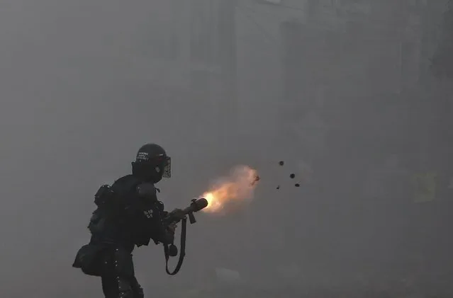 A police officer fires tear gas at protesters during a strike against tax reform in Cali, Colombia, Monday, May 3, 2021. Colombia's President Ivan Duque withdrew the government-proposed tax reform on Sunday. (Photo by Andres Gonzalez/AP Photo)