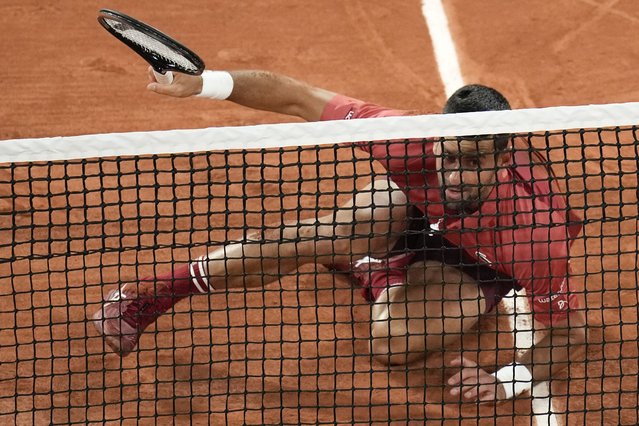 Serbia's Novak Djokovic slips when playing a shot close to the net during his first round match of the French Open tennis tournament against France's Pierre-Hugues Herbert at the Roland Garros stadium in Paris, Tuesday, May 28, 2024. (Photo by Christophe Ena/AP Photo)