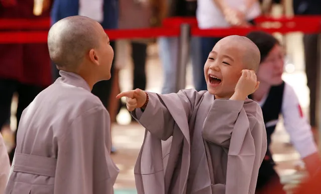 Two boys smiles after having their heads shaved during a service to celebrate Buddha's upcoming 2,560th birthday on May 14, at the Jogye Temple in Seoul, South Korea Monday, May 2, 2016. They are two of the ten children who entered the temple to have an experience of monks' life for two weeks. (Photo by Lee Jin-man/AP Photo)