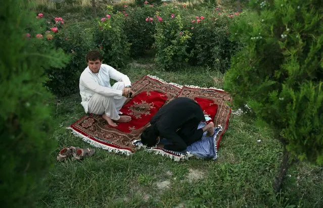 An Afghan man prays in a public park during the Muslim holy month of Ramadan, in Kabul, Afghanistan, Sunday, July 5, 2015. Muslims throughout the world are marking Ramadan, the holiest month in the Islamic calendar when devotees fast from dawn till dusk. (Photo by Massoud Hossaini/AP Photo)