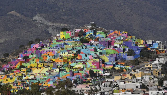 View of houses on a hill painted with vivid colours in Pachuca, Hidalgo, Mexico on April 4, 2017. The initiative, promoted by the Crime Prevention Secretariat seeks to motivate young people from communities under pressure of violence to participate and paint murals in their communities. (Photo by Yuri Cortez/AFP Photo)
