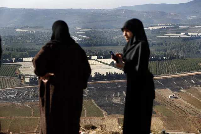 Lebanese villager women check their fields that burned on Sunday by the Israeli army shells, in the southern Lebanese border village of Maroun el-Ras, Lebanon, Monday, September 2, 2019. Hezbollah militants on Sunday fired a barrage of anti-tank missiles into Israel, prompting a reprisal of heavy Israeli artillery fire in a rare burst of fighting between the bitter enemies. (Photo by Hussein Malla/AP Photo)