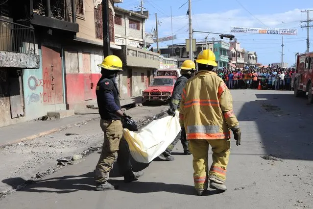 Emergency workers transport human remains found after a fuel truck exploded killing dozens of people amid reports that nearby residents had attempted to take fuel from the vehicle before it exploded, in Cap Haitien, Haiti on December 15, 2021. (Photo by Ralph Tedy Erol/Reuters)