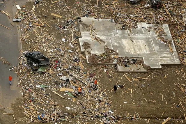 A concrete slab and rubble are all that is left of a home in a Vilonia, Arkansas neighborhood. (Photo by Danny Johnston/Associated Press)