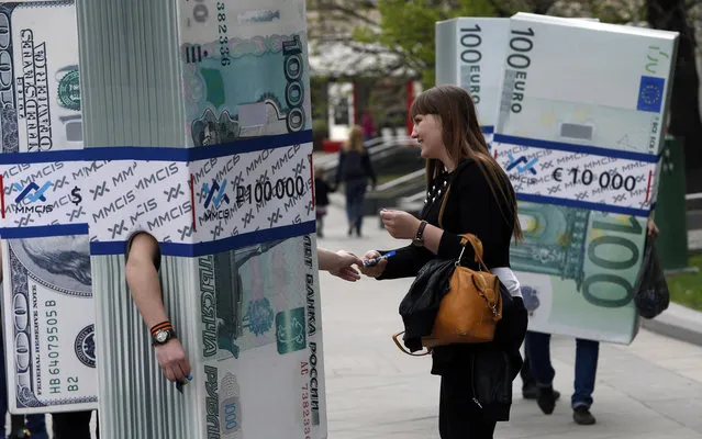 People dressed as blocks of currency notes as part of a marketing campaign walk in Moscow April 28, 2014. (Photo by Sergei Karpukhin/Reuters)