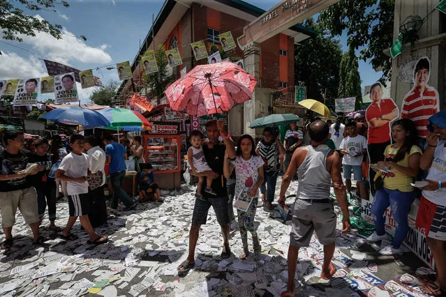 Filipinos walk along trash surrounding a public school turned into a polling precinct in Manila, Philippines, 09 May 2016. More than 54 million Filipinos were registered to vote on 09 May to elect a new President, Vice President, 12 senators and more than 18,000 regional and local positions. (Photo by Mark R. Cristino/EPA)