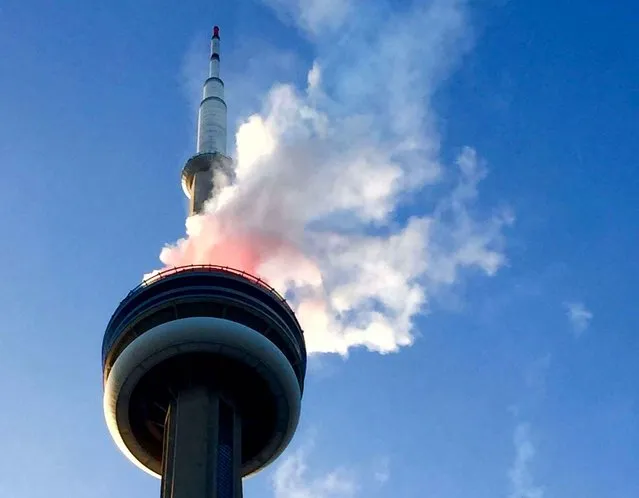 Smoke comes off the CN Tower in Toronto, Thursday July 9, 2015. Toronto fire officials say they responded to the reports and determined the smoke was from a fireworks display connected with the Pan Am Games, which officially open on Friday. (Photo by Ashton Lawrence/The Canadian Press via AP Photo)