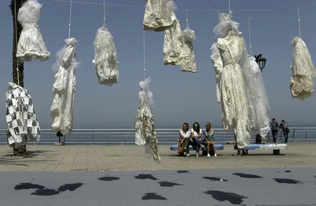 Lebanese women sit on a bench near an installation of wedding dresses by Lebanese artist Mireille Honein and Abaad NGO at Beirut's Corniche, on April 22, 2017, denouncing the article 522 of Lebanon's penal code allowing rapists who marry their victims to go free.
A proposal to scrap the article was introduced last year and approved by a parliamentary committee in February, but it must now be voted on by the full legislative body. (Photo by Patrick Baz/AFP Photo)
