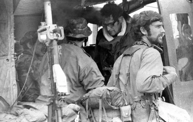 Four Vietnam War photojournalists are seen waiting for a helicopter flight into Laos to cover South Vietnamese forces attacking the Ho Chi Minh Trail on February 10, 1971. From left (inside helicopter): Keisaburo Shimamoto, Newsweek; Henri Huet, AP (back to camera); Larry Burrows, Life magazine; and Kent Potter, United Press International (standing at right). All four were killed in 1971 when the helicopter they were flying in was shot down. (Photo by Sergio Ortiz/AP Photo)