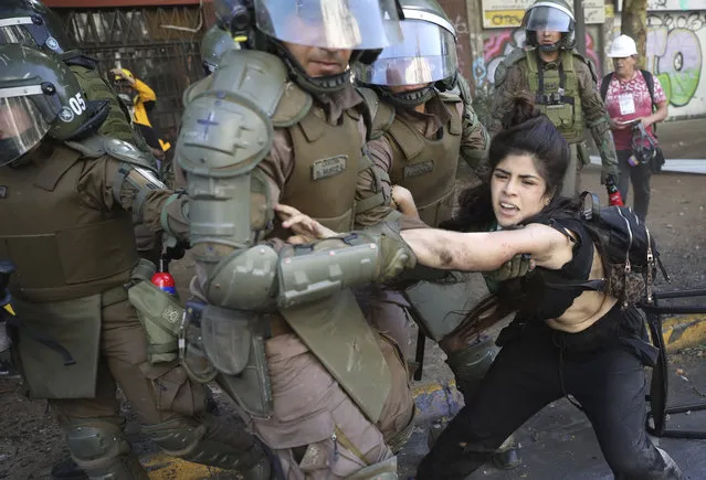 A protester is detained by police during an anti-government protest in Santiago, Chile, Thursday, October 24, 2019. (Photo by Rodrigo Abd/AP Photo)