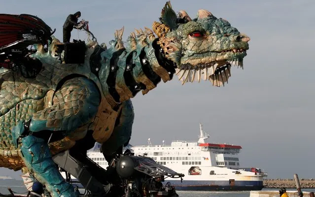 People gather to watch “The dragon of Calais” performance by “La Machine” company,  on October 30, 2019 in Calais, northern France. Spitting fire, water and smoke, a gigantic dragon “from another world” will enter Calais on November 1, 2019: 10 metres high, 25 metres long, the expected mechanical monster imagined by François Delaroziere will be at the centre of a three-day “urban show”, before becoming a tourist attraction. (Photo by Pascal Rossignol/Reuters)