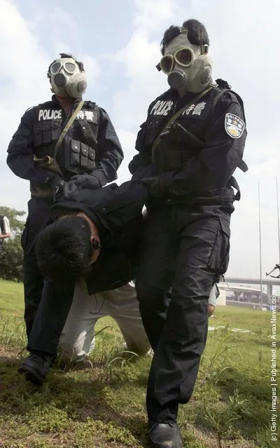Two members of the Special Weapons And Tactics Team escort a simulated suspect during an anti-terror drill