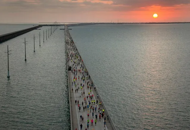 The sun rises above the Florida Keys Overseas Highway as a field of 1,500 runners competes in the Seven Mile Bridge Run on April 2, 2022, near Marathon, Florida. Holly Smith, of Marathon, won the women's division with a time of 00:43:23,while Collin Wainwright, of Springfield, Pennsylvannia, captured the overall men's division in 00:38:06. (Photo by Andy Newman/Florida Keys News Bureau/AFP Photo)