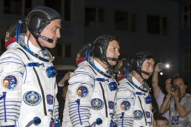 The International Space Station (ISS) crew members (L to R) Kjell Lindgren of the U.S., Oleg Kononenko of Russia and Kimiya Yui of Japan walk after donning space suits at the Baikonur cosmodrome, Kazakhstan, July 23, 2015. (Photo by Shamil Zhumatov/Reuters)