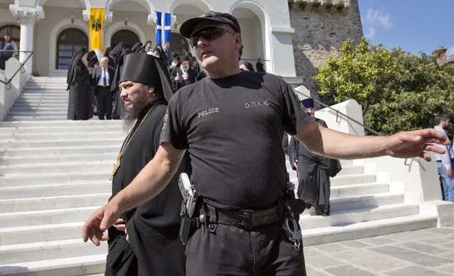 A Greek policeman provides security as Patriarch Kirill of Moscow meets with orthodox monks in Karyes, the capital of Mount Athos, Greece, Friday, May 27, 2016, ahead of Russia's president Putin visit. (Photo by Darko Bandic/AP Photo)